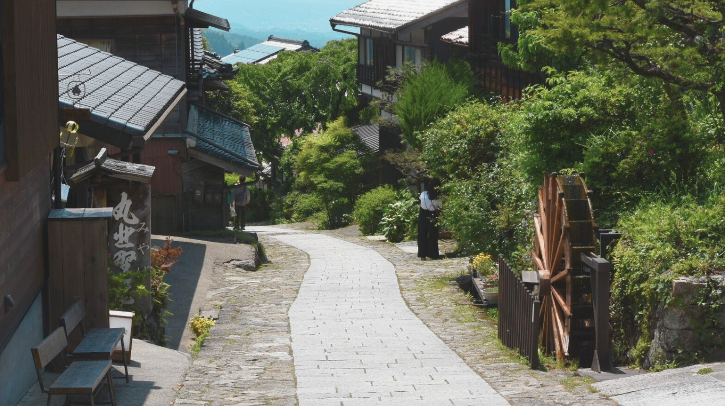 alt="馬籠宿の石畳と水車の風景"